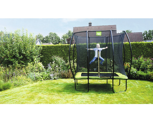 Enfant sautant sur un trampoline de jardin avec filet de sécurité