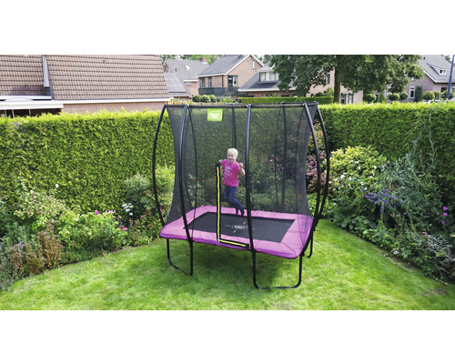Enfant sautant sur un trampoline de jardin rectangulaire avec filet de sécurité