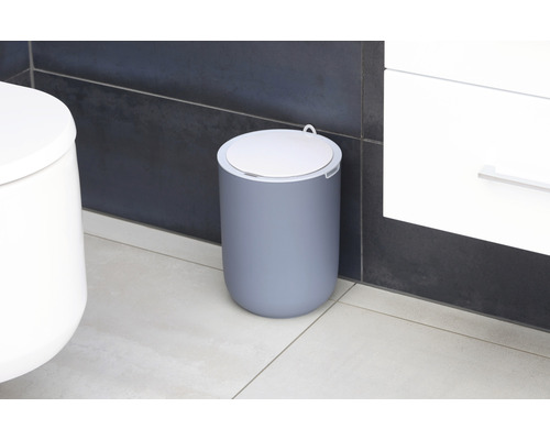 Poubelle à pédale grise avec couvercle dans la salle de bain