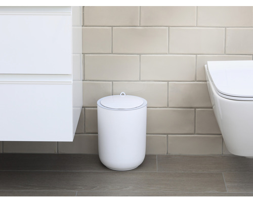 Scène de salle de bains avec une poubelle cosmétique blanche avec couvercle