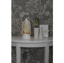 Scène décorative avec boule à neige, plante, gnome et cadeau sur une table