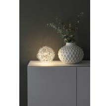 Dekorative Szene mit Kugelleuchte und Vase auf einem Schrank