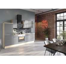 Cuisine moderne avec armoires grises, hotte aspirante et appareils intégrés dans une pièce avec mur en briques et table à manger