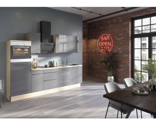 Cuisine moderne avec armoires grises, hotte aspirante et four intégré dans une pièce lumineuse avec table à manger