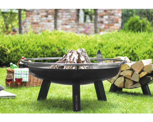 Feuerschale auf Rasen mit Holz und Picknickkorb