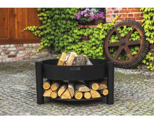Schwarze Feuerschale mit Holzablage im Garten