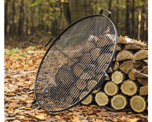 Grille ronde avec une pile de bois à l''extérieur