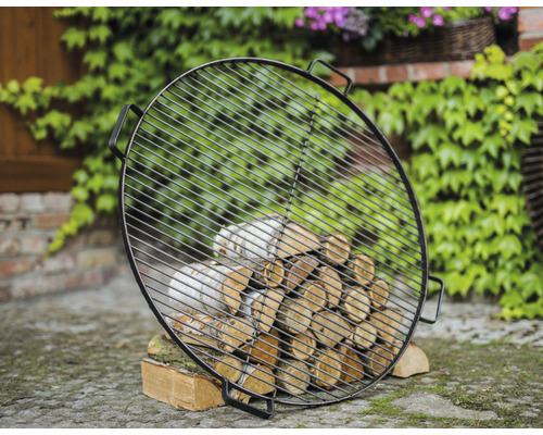 Grille de barbecue ronde avec bois de chauffage dans le jardin