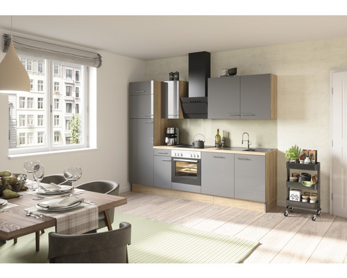 Cuisine claire avec armoires grises, table à manger et desserte de cuisine.