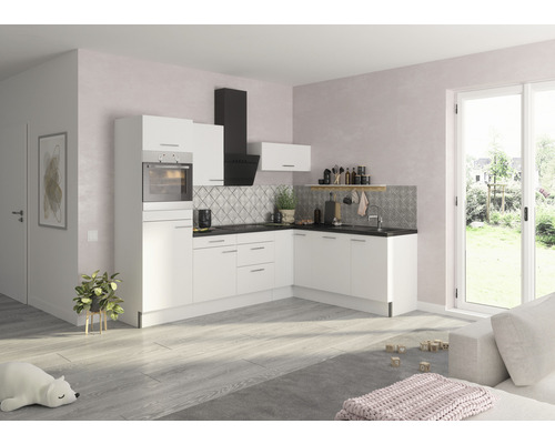 Cuisine claire avec armoires blanches, plan de travail noir et hotte aspirante.