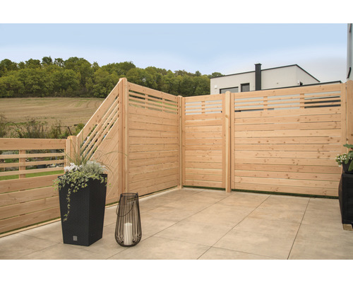 Clôture en bois sur une terrasse avec des jardinières et une lanterne.