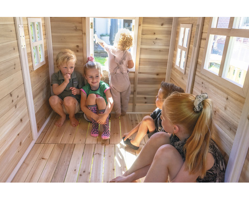 Des enfants jouent dans une cabane en bois avec des fenêtres