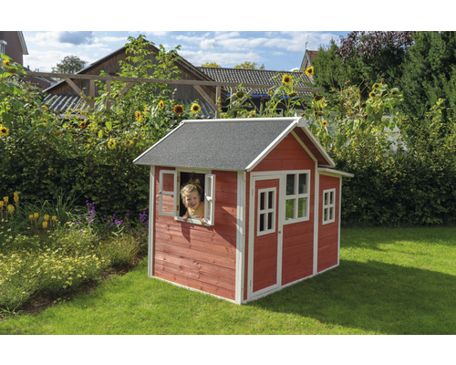 Maison de jeu en bois dans le jardin avec un enfant à la fenêtre