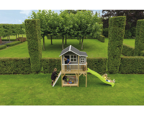 Spielhaus mit Rutsche und Sandkasten im Garten mit spielenden Kindern