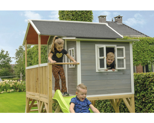 Kinderspielhaus mit Rutsche im Garten mit spielenden Kindern