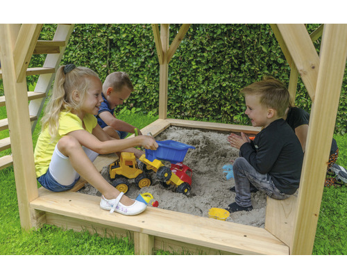 Des enfants jouent dans le bac à sable avec des véhicules jouets.