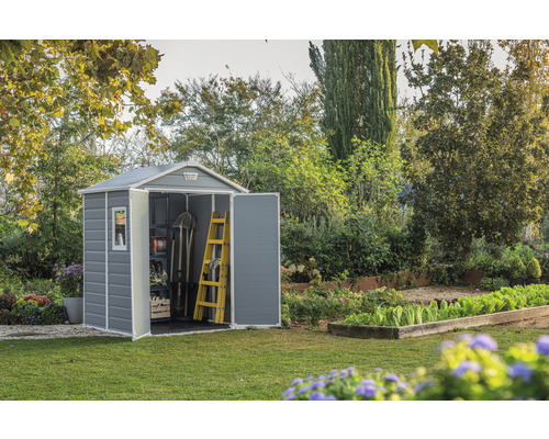Gartenschuppen aus Kunststoff mit geöffneten Türen und Gartengeräten im Inneren in einem Garten.