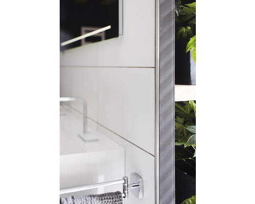 Gros plan d''une salle de bains avec lavabo, porte-serviettes, miroir et plantes