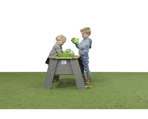 Des enfants jouent avec un potager surélevé en bois dans le jardin.