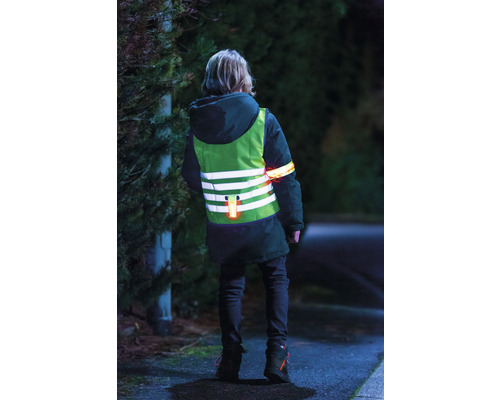 Kind mit Sicherheitsweste und Armband für bessere Sichtbarkeit im Dunkeln