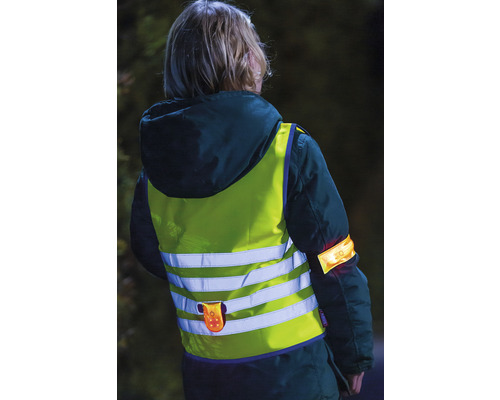 Kind mit Warnweste und Armband für mehr Sicherheit im Dunkeln