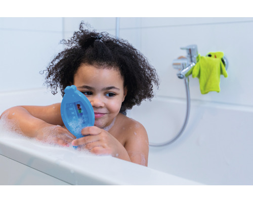 Un enfant dans la baignoire avec un thermomètre de bain
