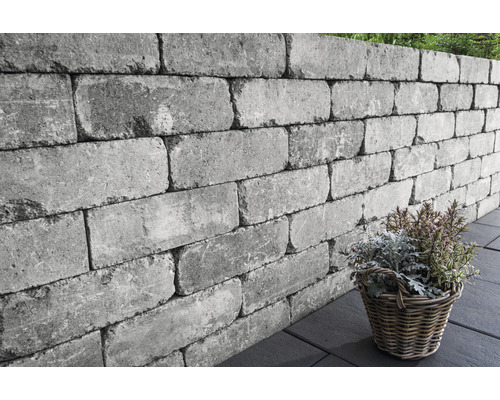 Des pierres de mur grises forment un mur de jardin avec un panier