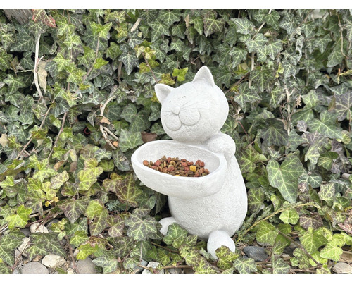 Distributeur d''aliments pour chats en forme de chat devant un fond de lierre