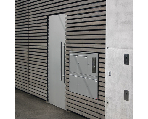 Façade avec éléments en bois, porte, batterie de boîtes aux lettres et élément en béton