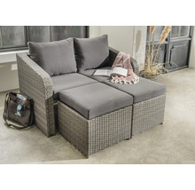 Graue Loungeecke aus Rattan mit Kissen und Fußhockern auf einer Terrasse