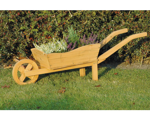 Botte en bois en forme de brouette avec plantations dans le jardin