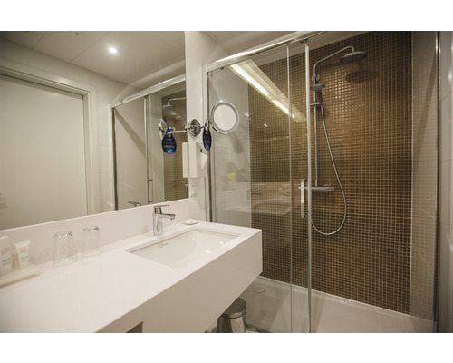 Badezimmer mit Waschbecken, Spiegel und Dusche