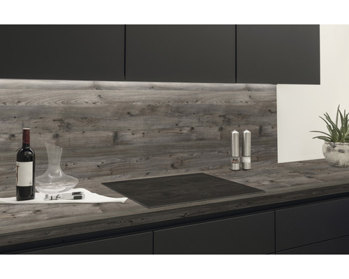 Cuisine avec plaque de cuisson, plan de travail et crédence aspect bois