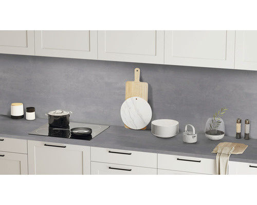 Scène de cuisine avec plan de travail, plaque de cuisson, ustensiles de cuisine et vaisselle devant des armoires blanches