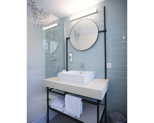 Salle de bain moderne avec douche, lavabo, miroir et serviettes