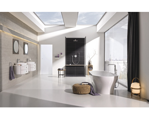 Salle de bains avec baignoire, douche, lavabos et lucarne pour la lumière du jour