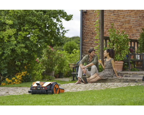 Scène de jardin avec robot tondeuse et couple détendu