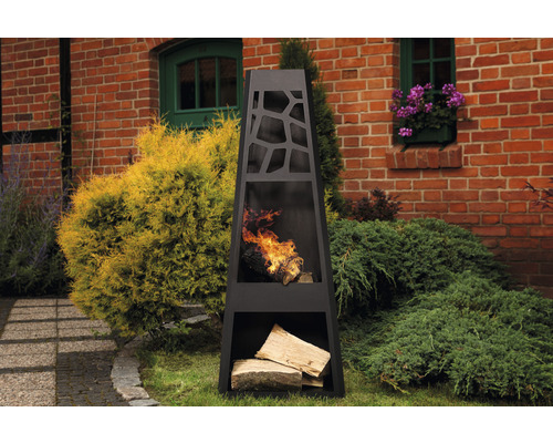 Foyer en acier avec bûches de bois dans le jardin