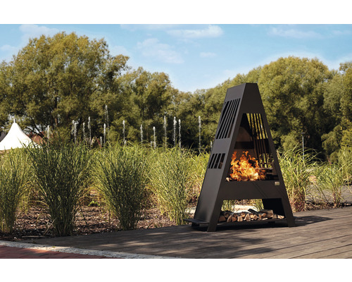 Cheminée d''extérieur en acier en forme de A avec du bois et du feu dans le jardin