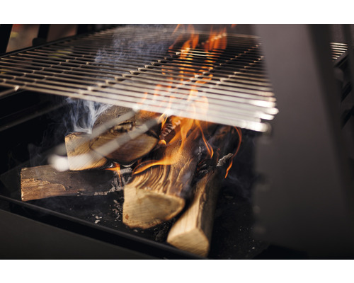 Barbecue au charbon de bois avec bois brûlant et grille