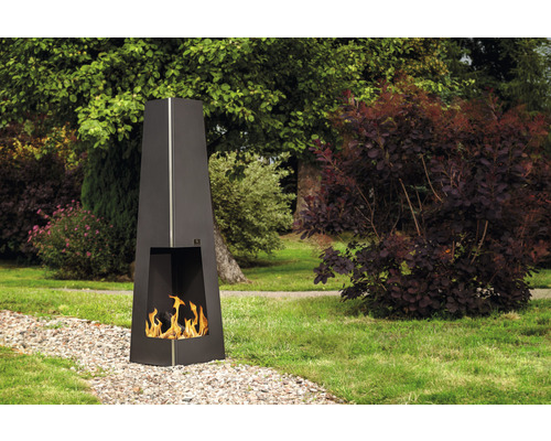 Schwarzer Outdoor-Kamin mit Flammen in einer Gartenszene.