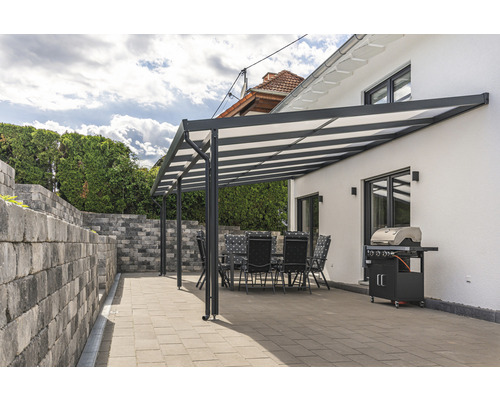 Terrasse mit Terrassenüberdachung, Gartentisch, Stühlen und Grill neben dem Haus