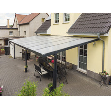 Terrassenüberdachung mit Tisch und Stühlen im Garten.