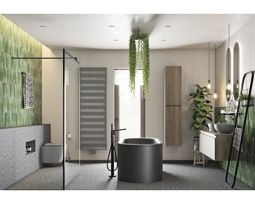 Salle de bains lumineuse avec baignoire, lavabo, miroir, porte-serviettes et plantes pour une ambiance naturelle.