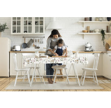 Helle Küche mit Mutter und Kind beim Backen am Tisch mit Tischdecke mit Blumenmuster