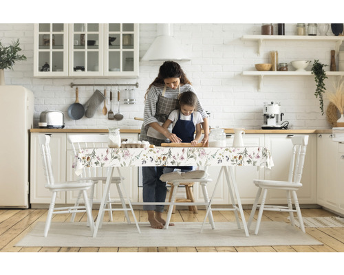 Mutter und Kind backen in der Küche mit Tischdecke mit Pflanzenmuster, Stühlen und Küchenutensilien
