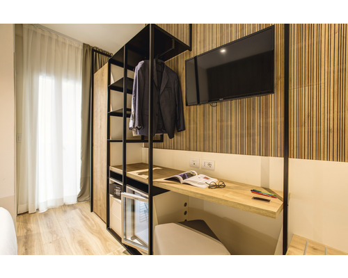Modernes Hotelzimmer mit Kleiderschrank, Schreibtisch und Fernseher
