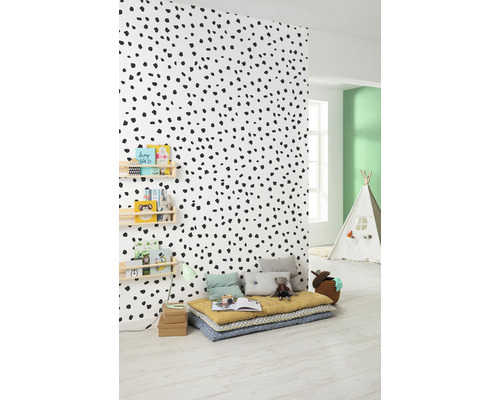 Chambre d''enfant avec papier peint à pois, coussins de sol et étagère à livres