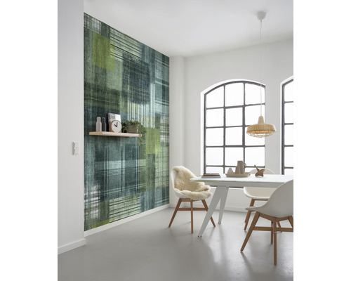 Salle à manger moderne avec papier peint à motifs dans les tons de vert et de bleu, ainsi qu''une table à manger avec des chaises.