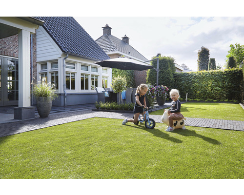 Jardin avec pelouse, mobilier de jardin et enfants qui jouent